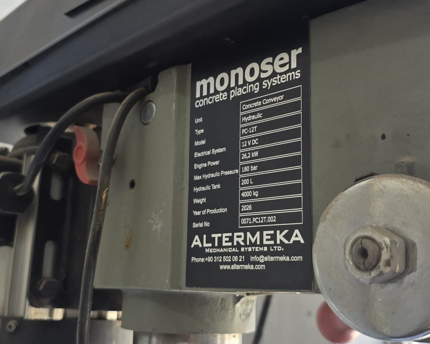 Sahada monte makine plakası geniş açı — beton pompası konveyörünün şasi kirişine sabitlenmiş teknik değer tablolu isim plakası | Divan Etiket Ankara