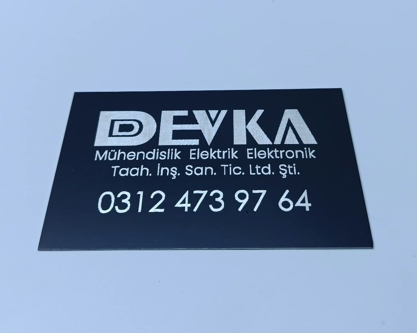 DEVKA Mühendislik için fiber lazer gravürle üretilmiş lacivert anodize alüminyum logo plakası — Divan Etiket üretimi